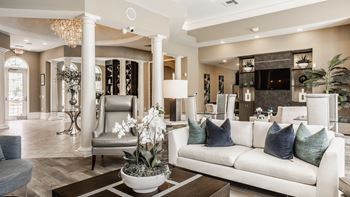 A living room with a white couch and a chandelier.